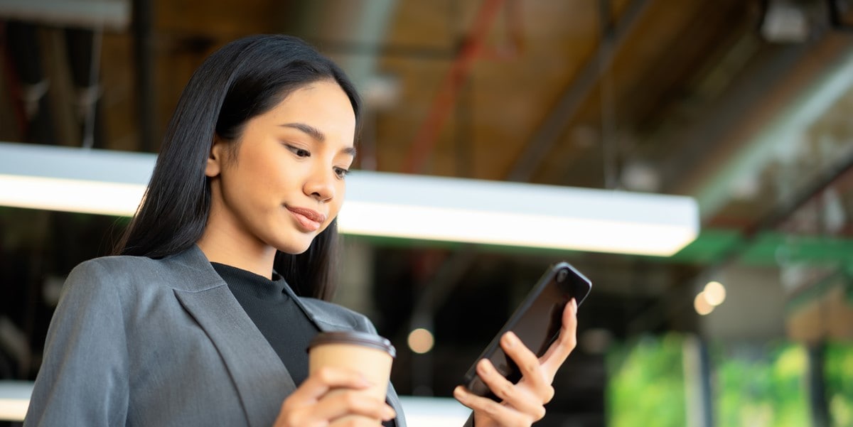 young woman in office looking at phone